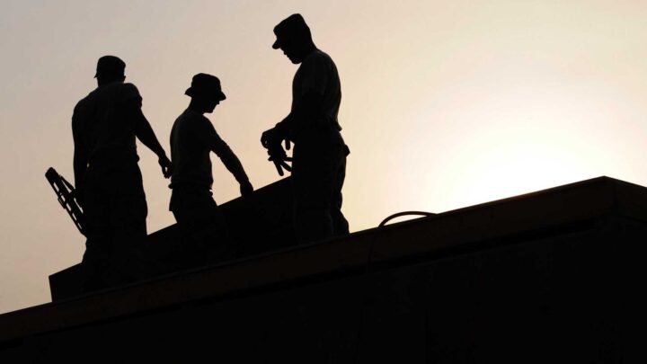 OSHA - photo of 3 workmen on a roof at sunset